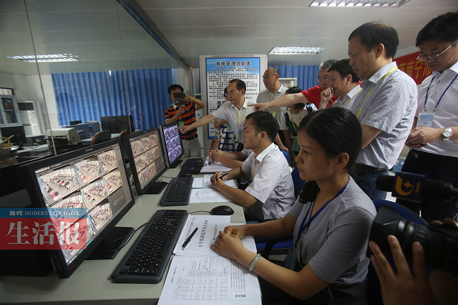 考务职员在沛鸿中学考点寓目视频监控。