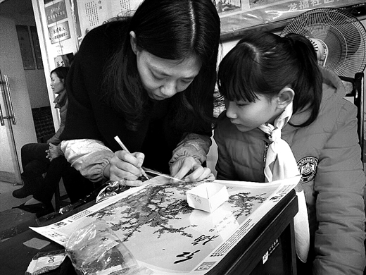 “校外教室”领导教师王艳正在指导小朋侪建造手工贴画